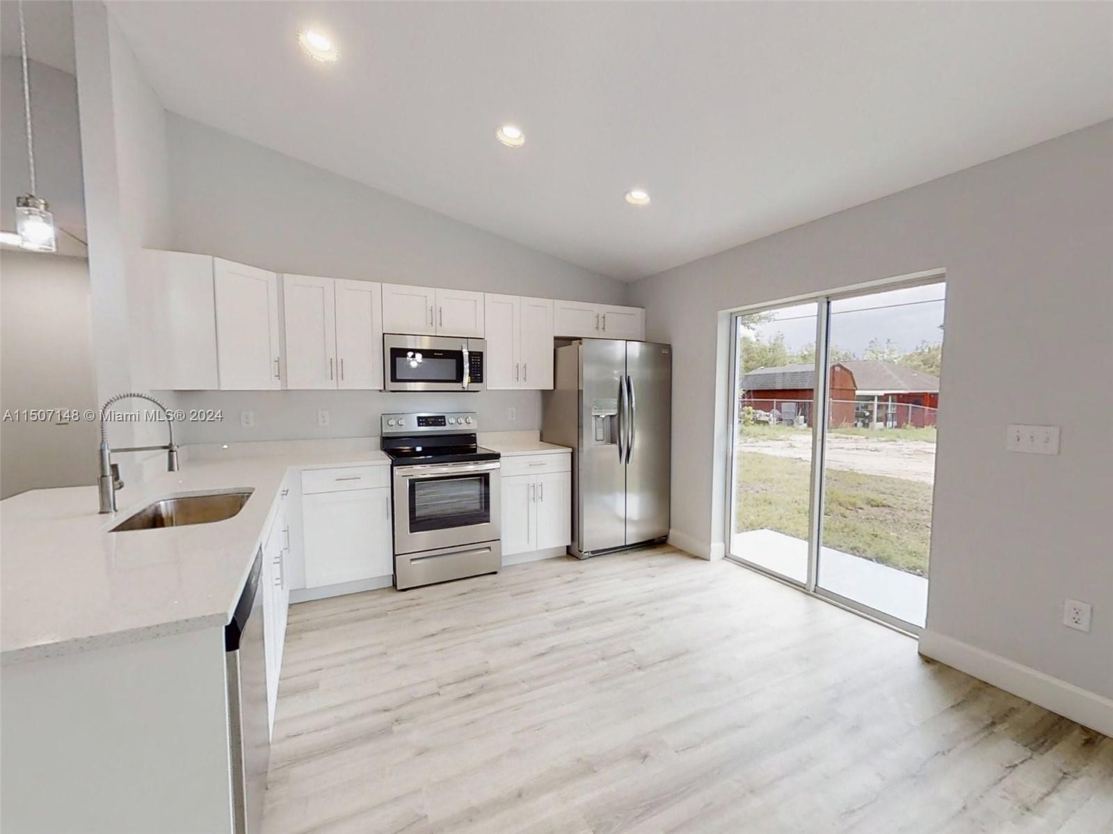 14512 Southwest 25th Lane Ocala, FL 34481 - Photo 10 of 30 a kitchen with granite countertop a refrigerator and a sink