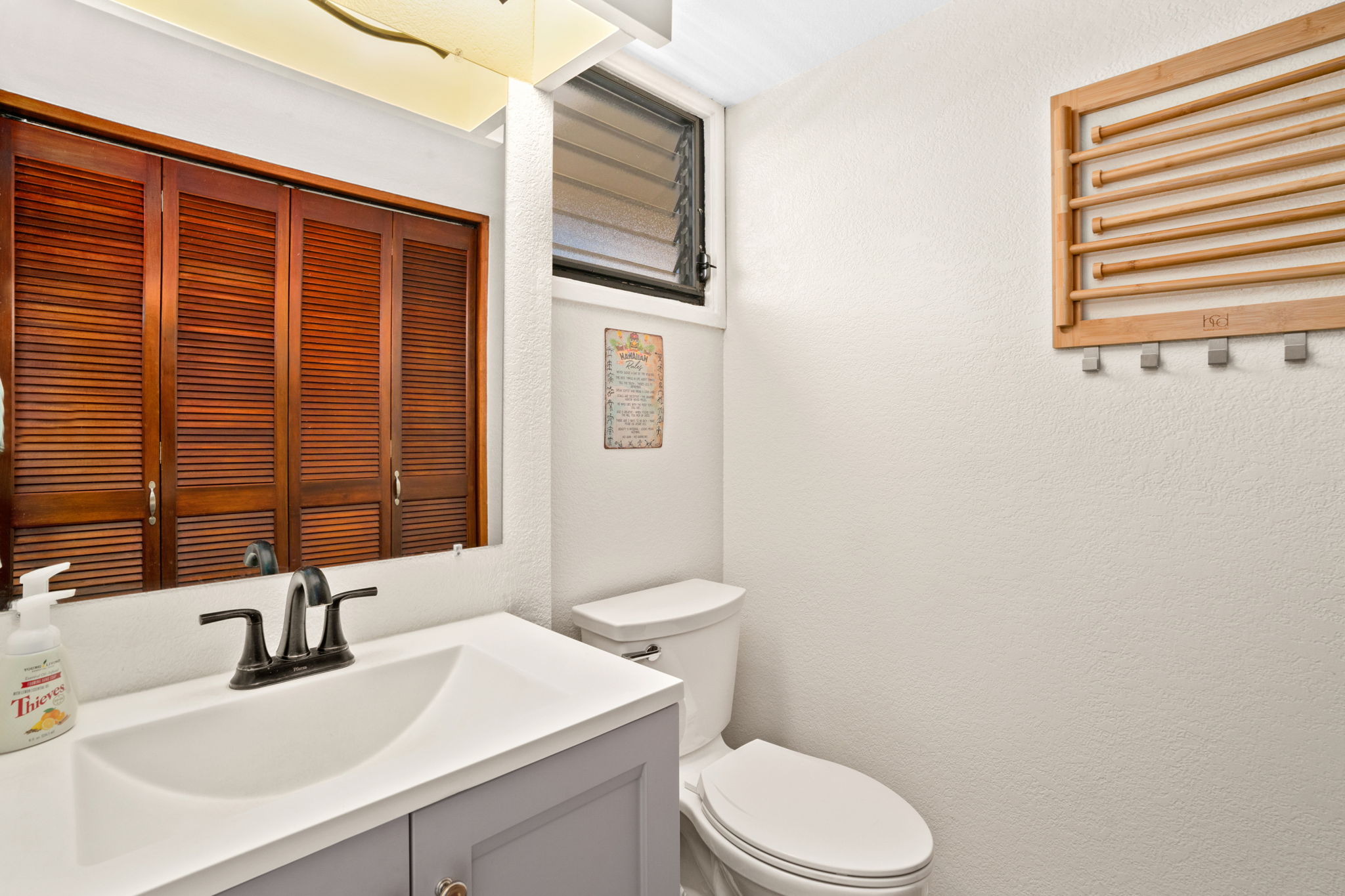 1661 Pee Road, Unit I302 Koloa, HI 96756 - Photo 11 of 30 a bathroom with a sink a toilet and mirror