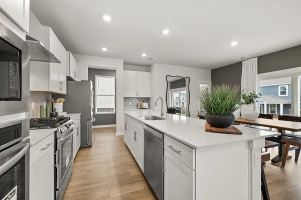 a kitchen with stainless steel appliances kitchen island granite countertop a dining table chairs and view kitchen