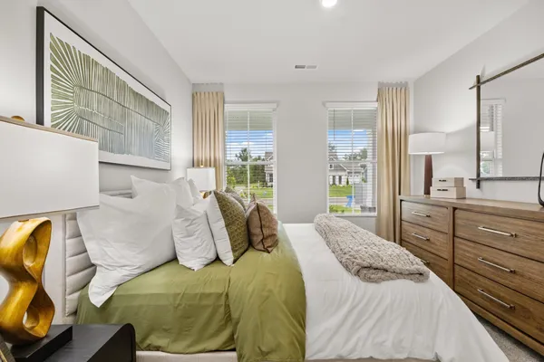 a bedroom with a bed and a potted plant