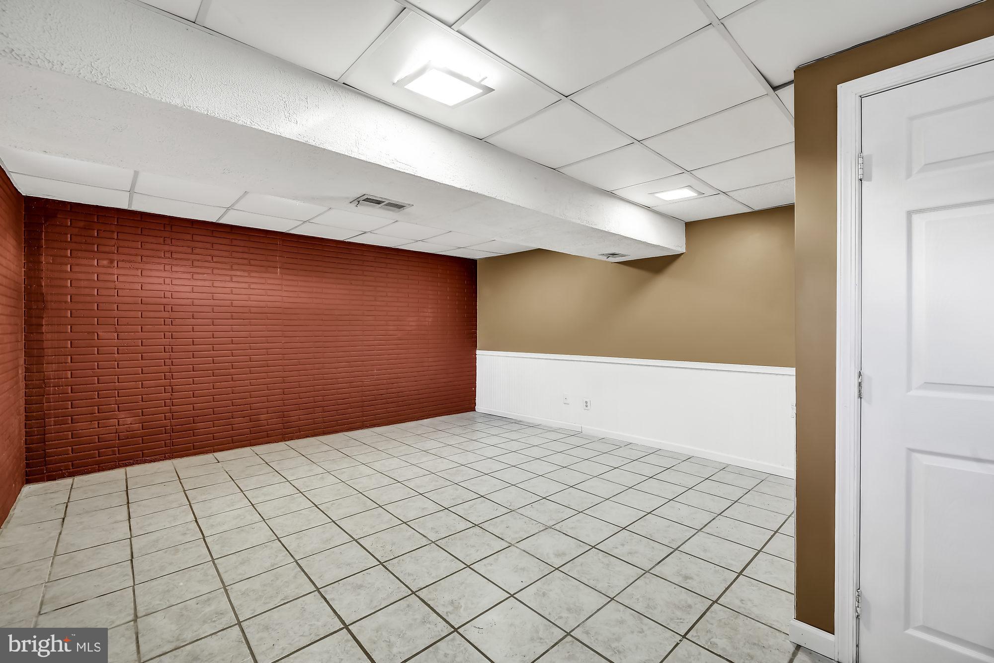 72 Ridgelawn Road, Unit D Reisterstown, MD 21136 - Photo 23 of 28 Lower level family room w/tile flooring