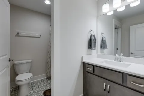 a bathroom with a sink a toilet and a mirror