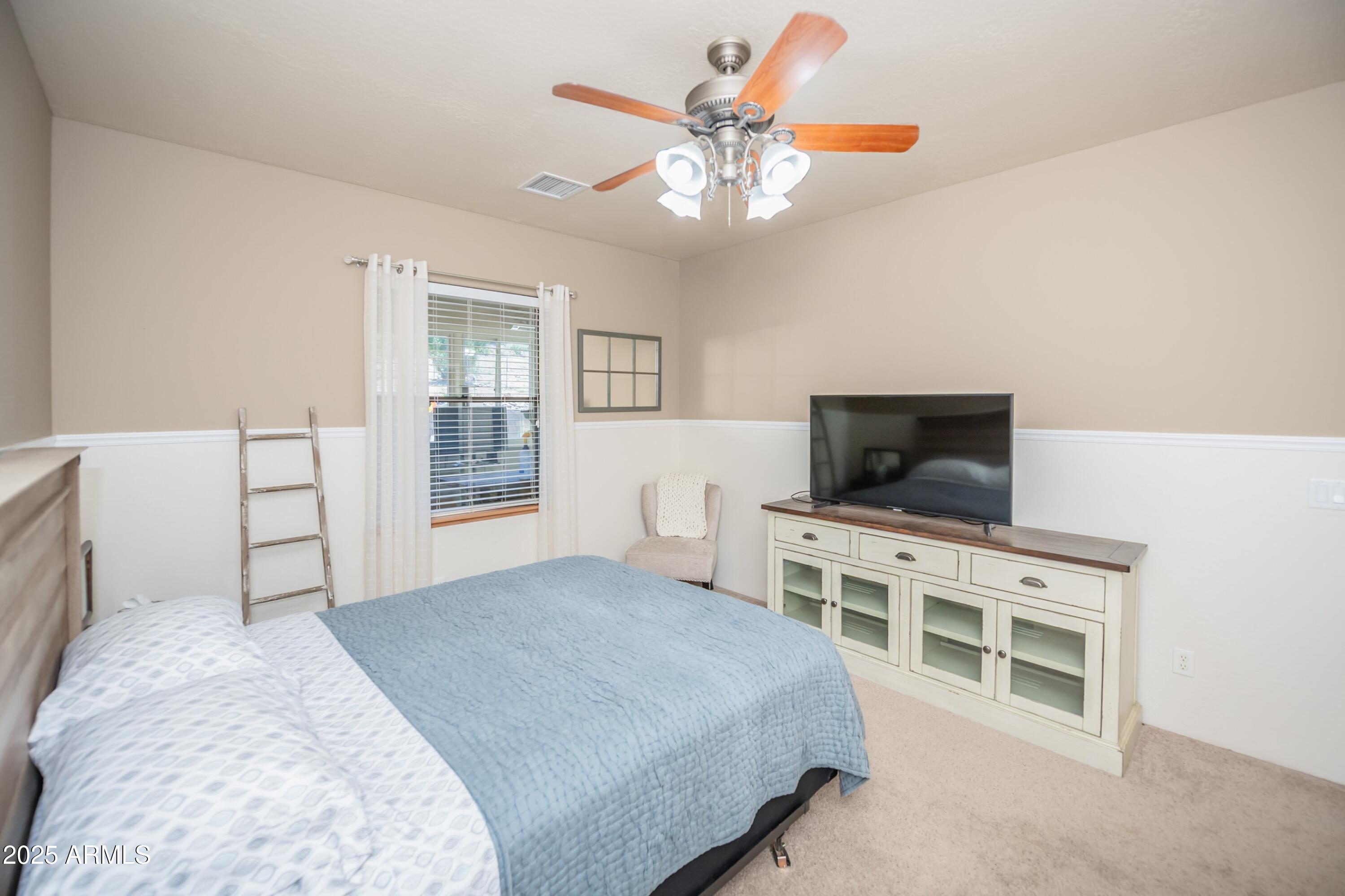 171 South Enchanted Road Dewey, AZ 86327 - Photo 25 of 62 a bedroom with a bed and a flat screen tv
