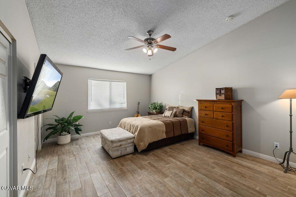 44115 Hunter Court Lancaster, CA 93536 - Photo 11 of 23 a bedroom with a bed and a flat tv screen on dresser
