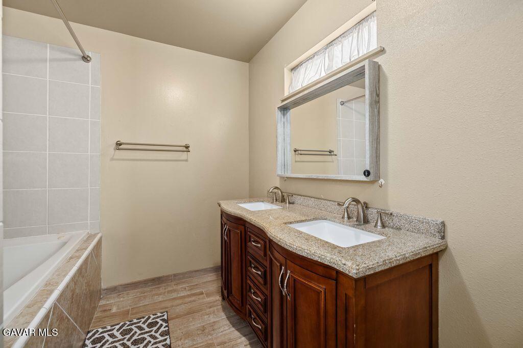 44115 Hunter Court Lancaster, CA 93536 - Photo 13 of 23 a bathroom with a sink a vanity and a mirror
