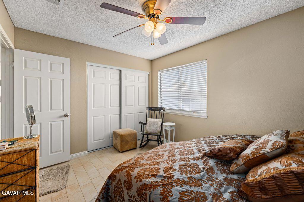 44115 Hunter Court Lancaster, CA 93536 - Photo 16 of 23 a bedroom with a bed and a chandelier