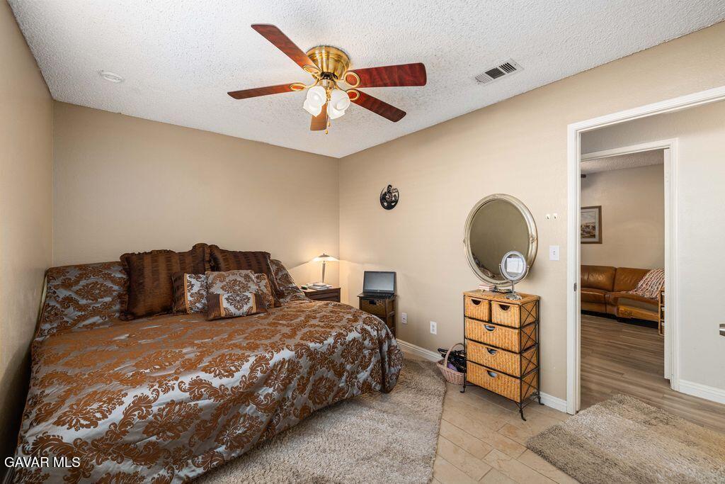 44115 Hunter Court Lancaster, CA 93536 - Photo 17 of 23 a bed room with a bed and a chandelier