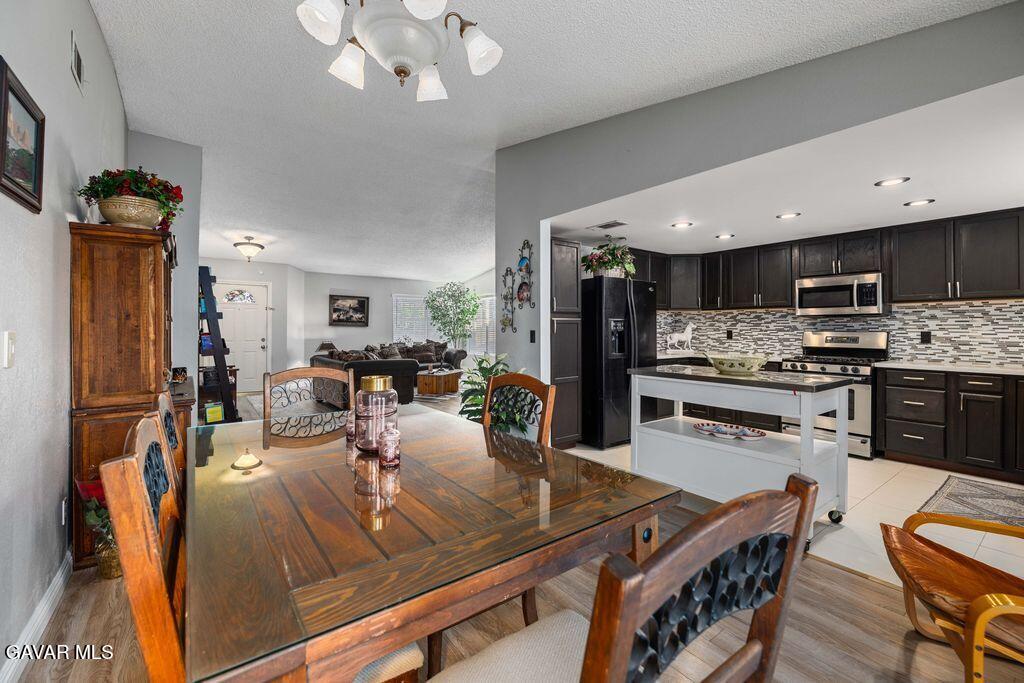 44115 Hunter Court Lancaster, CA 93536 - Photo 8 of 23 a view of a dining room kitchen with furniture and chandelier
