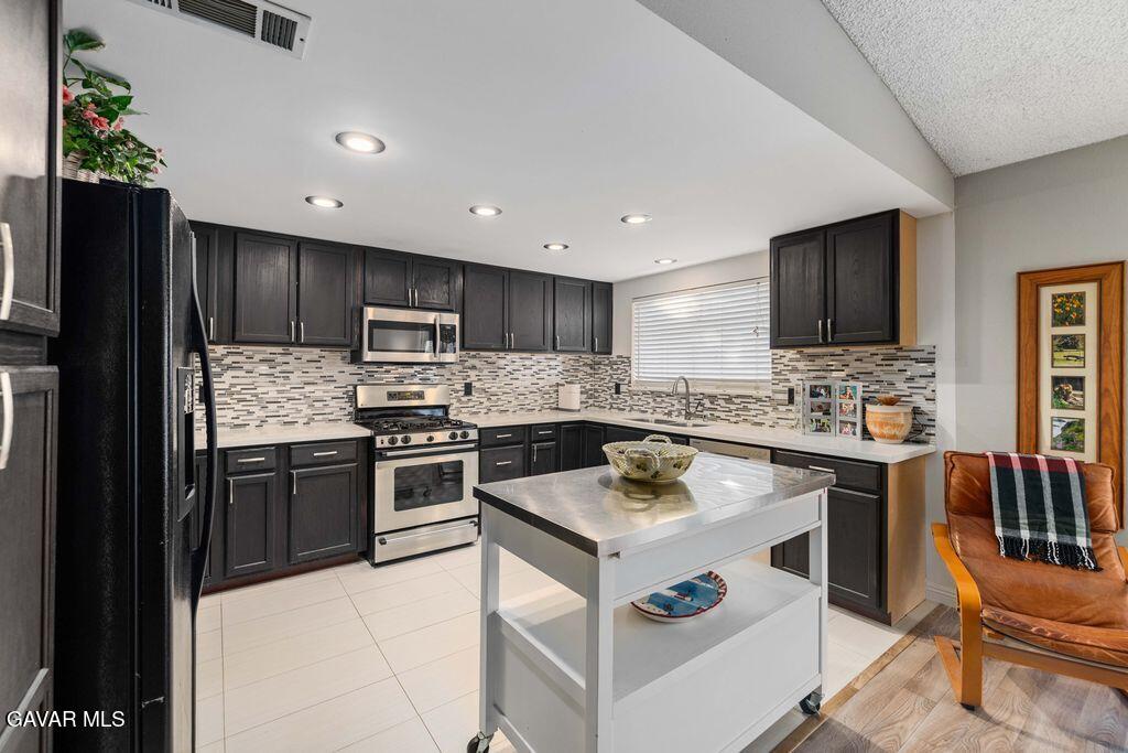 44115 Hunter Court Lancaster, CA 93536 - Photo 9 of 23 a kitchen with a refrigerator stove top oven and sink