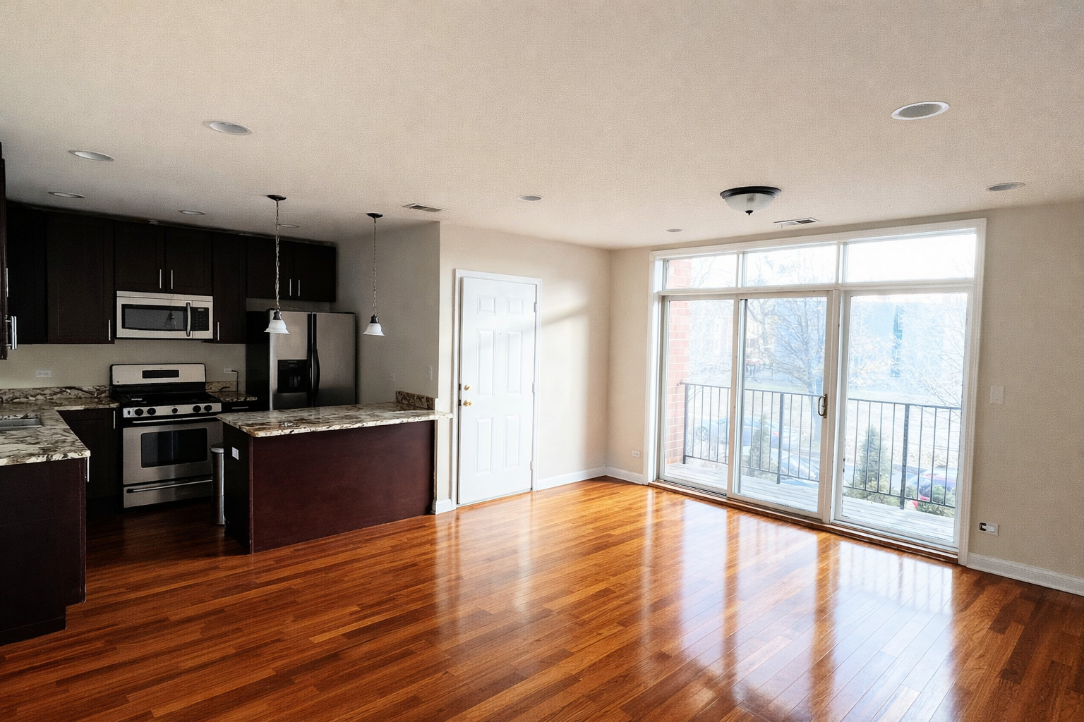 3336 West 19th Street, Unit 1W Chicago, IL 60623 - Photo 3 of 10 a large kitchen with stainless steel appliances granite countertop a stove and a wooden floors