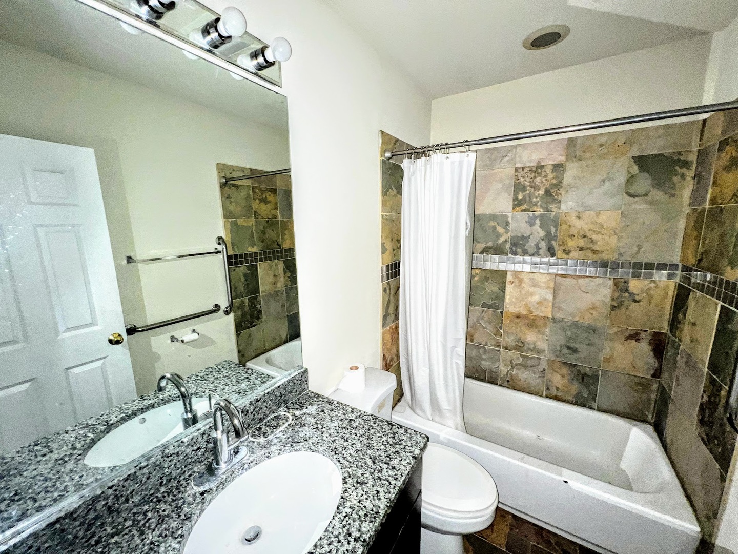 3336 West 19th Street, Unit 1W Chicago, IL 60623 - Photo 9 of 10 a bathroom with a granite countertop sink mirror toilet and bathtub
