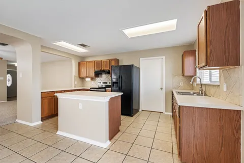 a kitchen with stainless steel appliances a refrigerator sink and cabinets