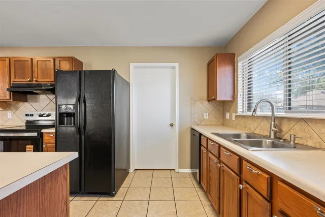 a kitchen with stainless steel appliances granite countertop a refrigerator and a sink
