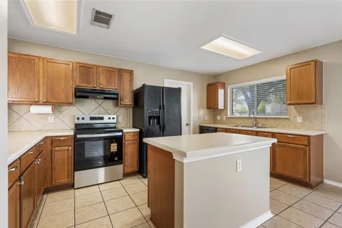 a kitchen with stainless steel appliances a sink stove refrigerator and a window