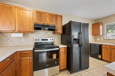 a kitchen with stainless steel appliances granite countertop a refrigerator and a stove top oven