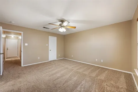 a view of an empty room with a chandelier fan