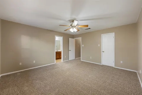 a view of an empty room with a ceiling fan