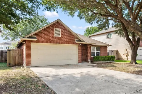 a view of a house with a yard and large tree