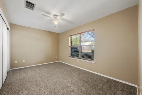 an empty room with window and fan