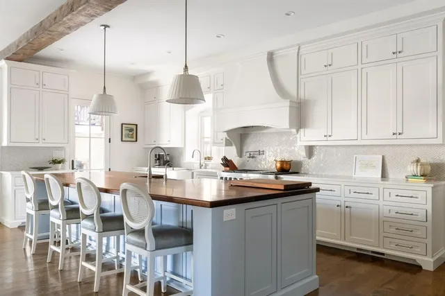 a kitchen with white cabinets and sink
