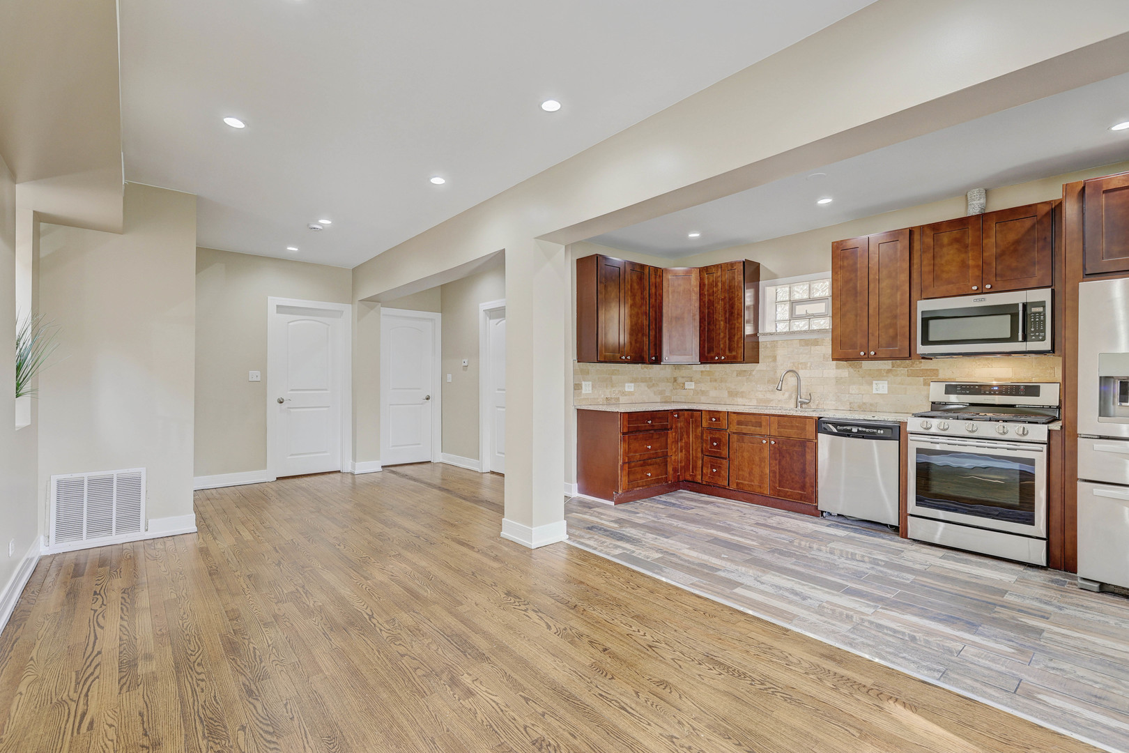 5040 West Berenice Avenue, Unit 1 Chicago, IL 60641 - Photo 5 of 18 a large kitchen with stainless steel appliances granite countertop a stove and a sink