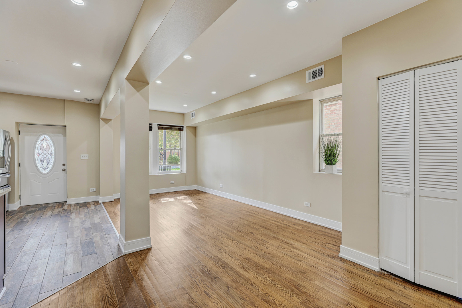 5040 West Berenice Avenue, Unit 1 Chicago, IL 60641 - Photo 9 of 18 an empty room with wooden floor and windows