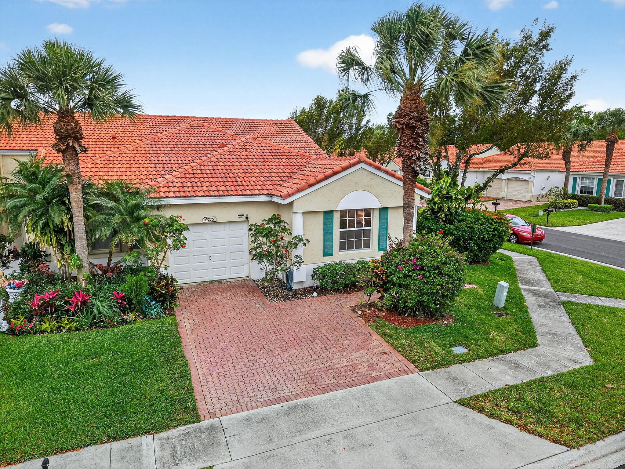 a front view of a house with a yard and potted plants