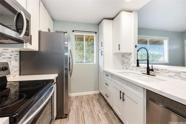 a kitchen with stainless steel appliances granite countertop a sink stove and refrigerator