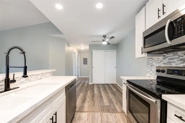 a kitchen with stainless steel appliances kitchen island a white stove top oven and sink
