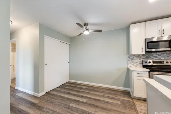 a kitchen with stainless steel appliances a stove a microwave and white cabinets