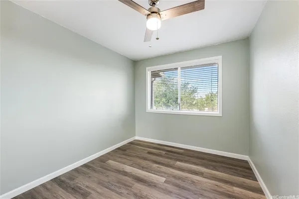 an empty room with a window and a ceiling fan