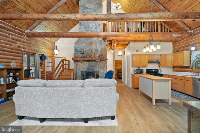 a kitchen with stainless steel appliances kitchen island granite countertop a table chairs sink and cabinets