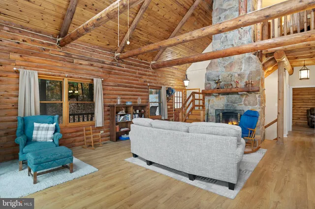 a living room with furniture a fireplace and a floor to ceiling window