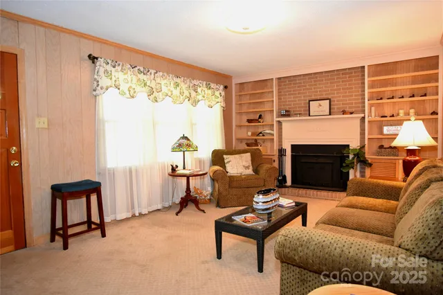 a living room with furniture a fireplace and a large window
