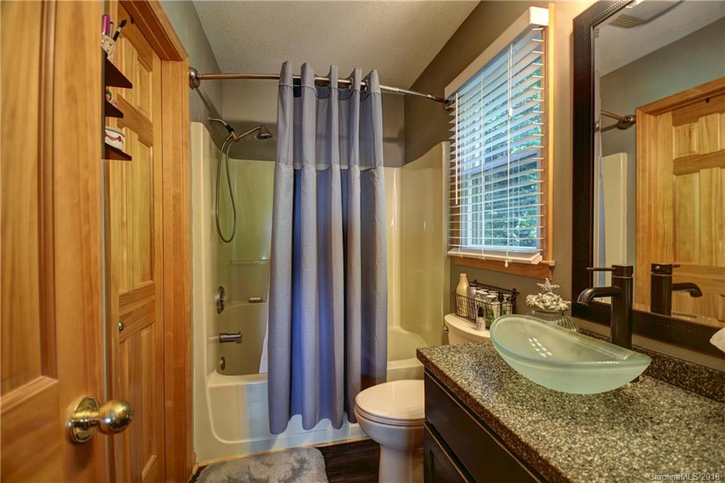 204 Kings Ridge Road Maggie Valley, NC 28751 - Photo 14 of 34 a bathroom with a granite countertop sink and a mirror