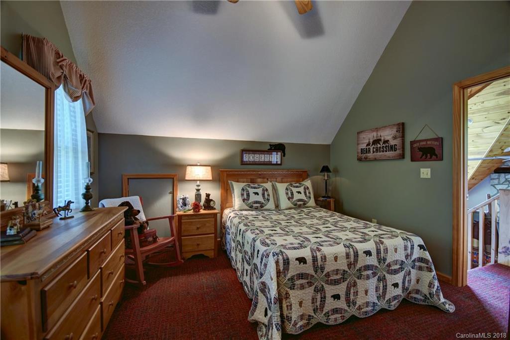 204 Kings Ridge Road Maggie Valley, NC 28751 - Photo 18 of 34 a bedroom with a bed and a table in it