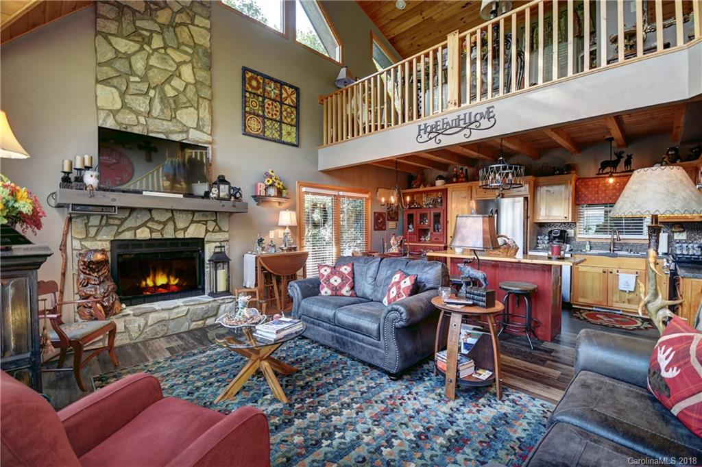 204 Kings Ridge Road Maggie Valley, NC 28751 - Photo 8 of 34 a living room with furniture a fireplace and a flat screen tv
