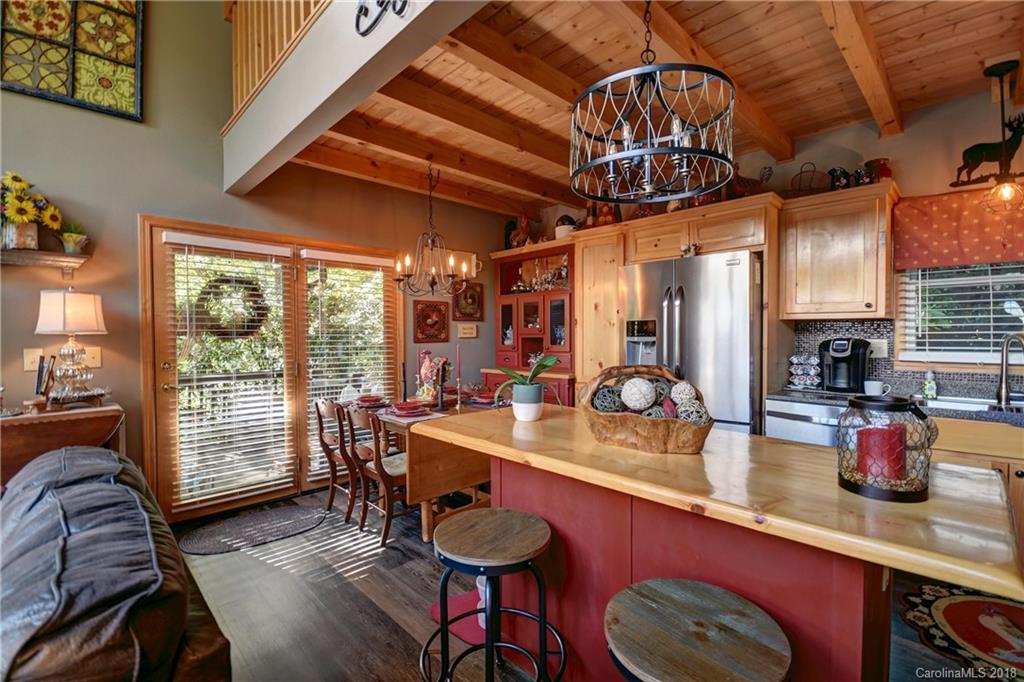 204 Kings Ridge Road Maggie Valley, NC 28751 - Photo 10 of 34 a kitchen with a sink a stove and chairs