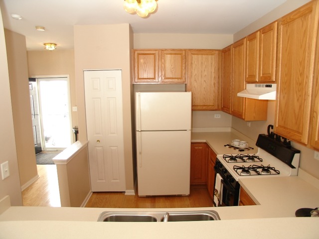 2408 Golf Ridge Circle Naperville, IL 60563 - Photo 5 of 25 a kitchen with a refrigerator a stove top oven a sink and cabinets