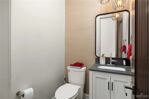 a bathroom with a sink vanity mirror and toilet