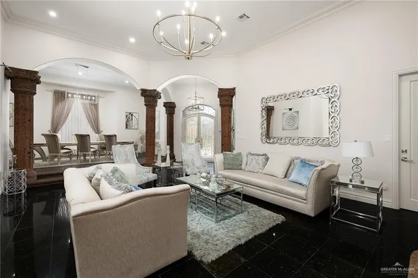 a living room with furniture chandelier and a table