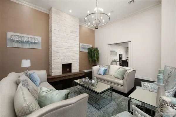 a living room with furniture a chandelier and a fireplace