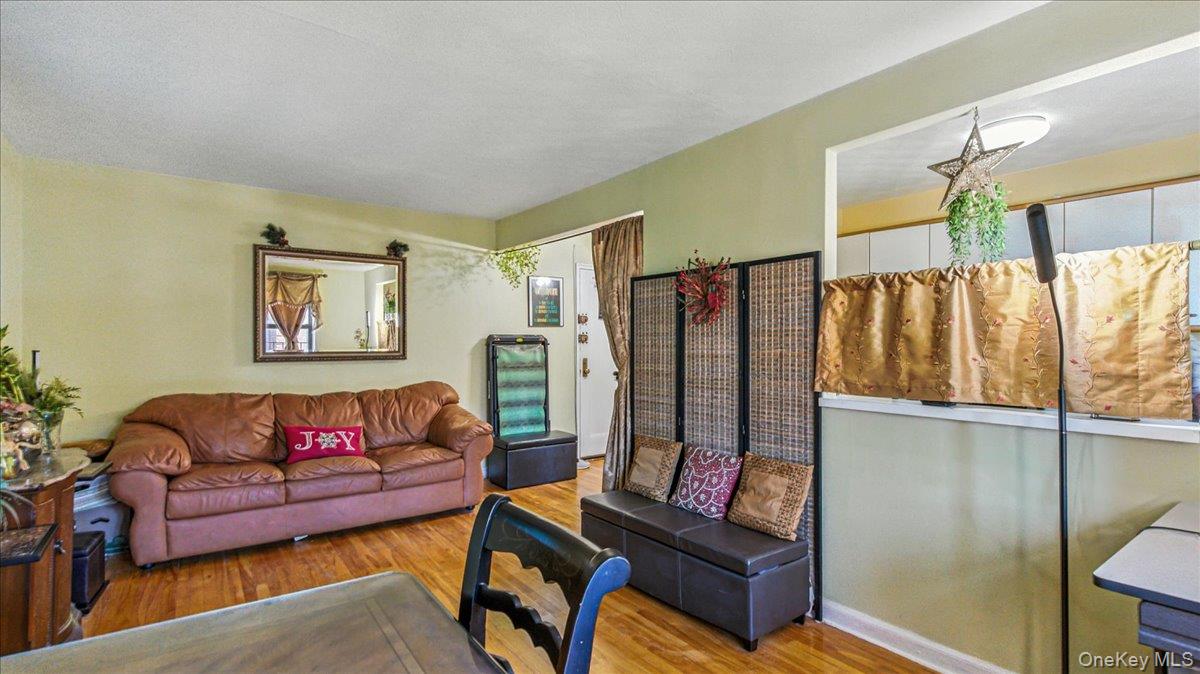 88-10 34th Avenue, Unit 5C Queens, NY 11372 - Photo 7 of 16 a living room with furniture a rug and a wall painting