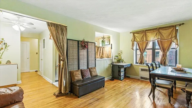 a living room with furniture a large window and wooden floor