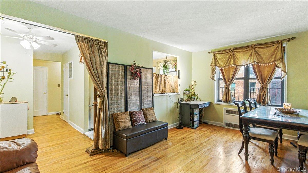 88-10 34th Avenue, Unit 5C Queens, NY 11372 - Photo 8 of 16 a living room with furniture a large window and wooden floor