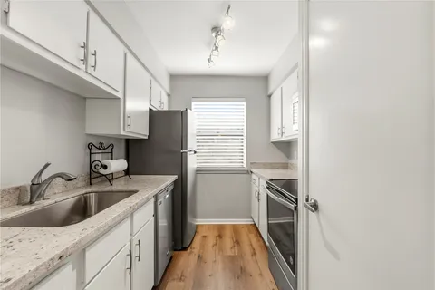 a kitchen with a sink stove top oven and cabinets