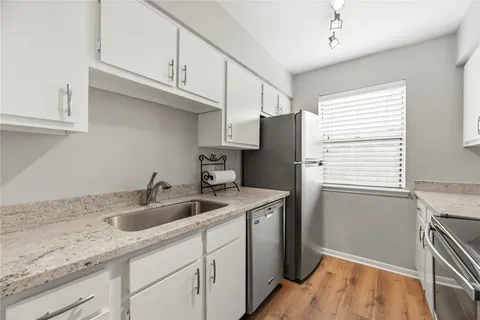 a kitchen with stainless steel appliances granite countertop a sink a refrigerator and a stove