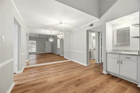 a view of a hallway with wooden floor and a living room