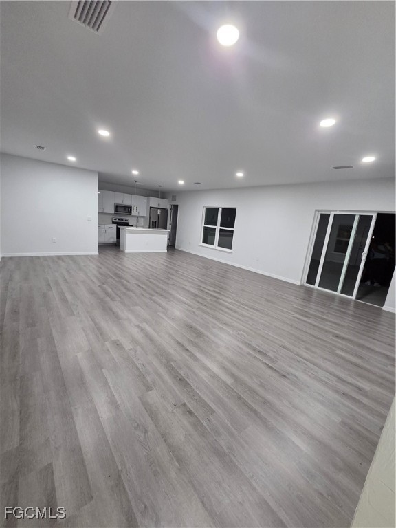 15 Hampton Avenue Lehigh Acres, FL 33936 - Photo 6 of 14 an empty room with wooden floor and windows