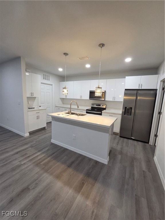 15 Hampton Avenue Lehigh Acres, FL 33936 - Photo 9 of 14 a large kitchen with stainless steel appliances a stove a sink dishwasher a refrigerator and white cabinets with wooden floor